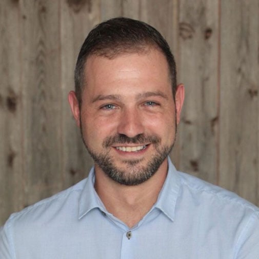 Lächelnder Mann vor Holzwand